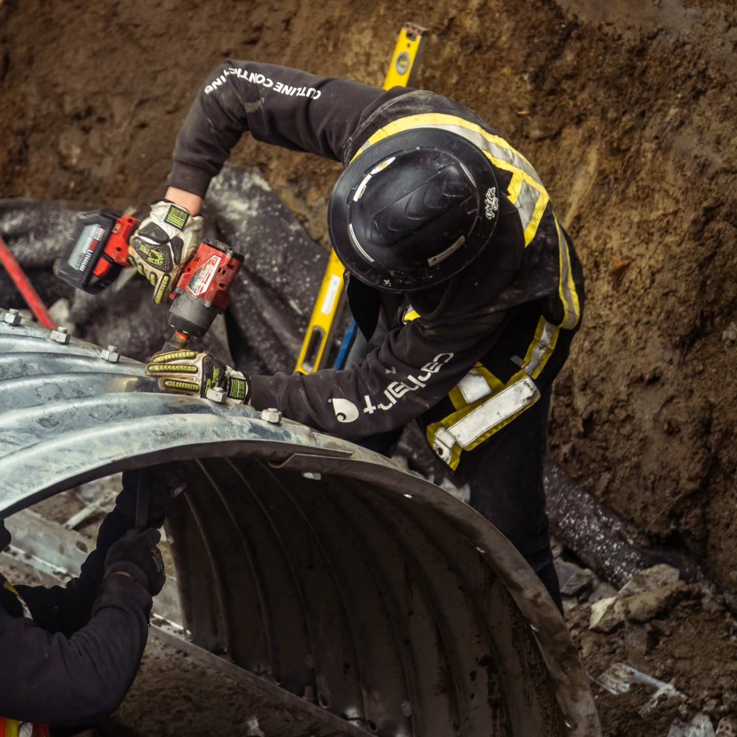 Radius Excavation crew bolting a large culvert section in the trench