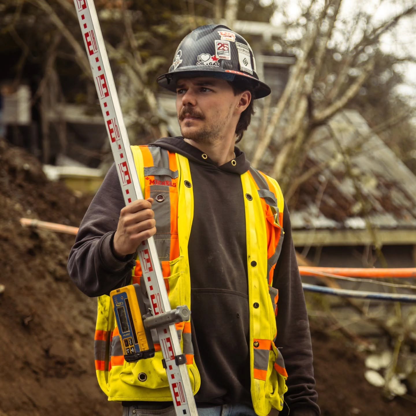 Radius Excavation surveyor holding a grade rod on site