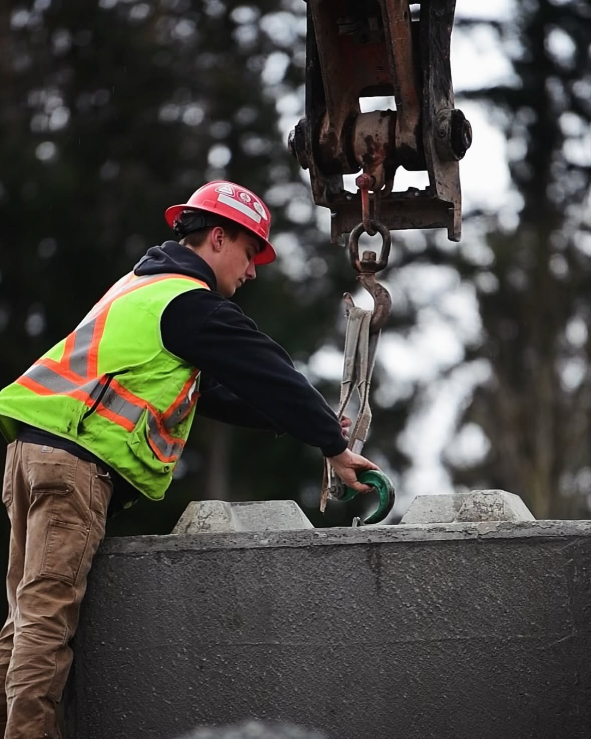 Radius Excavation crew member rigging a concrete lock block with an excavator
